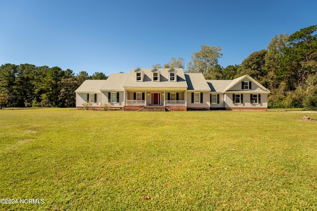 cape cod-style house featuring a front yard and covered porch