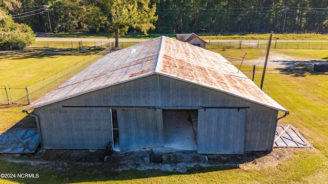 view of outdoor structure with a rural view and a yard