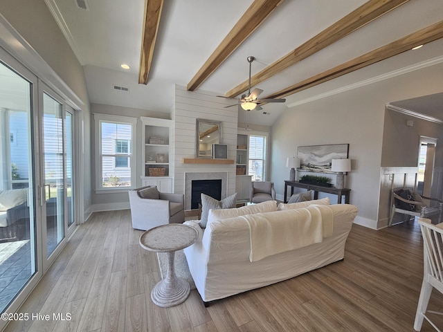 living room featuring a fireplace, wood finished floors, visible vents, baseboards, and ornamental molding