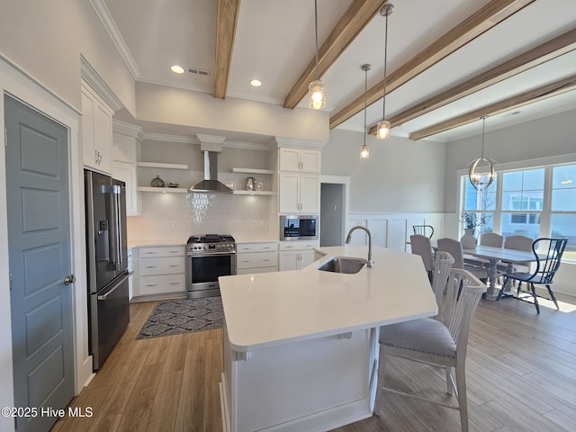 kitchen featuring wall chimney exhaust hood, appliances with stainless steel finishes, a sink, open shelves, and beam ceiling