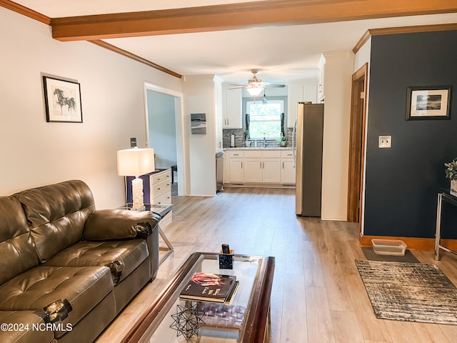 living room featuring ceiling fan, crown molding, beam ceiling, light hardwood / wood-style flooring, and sink