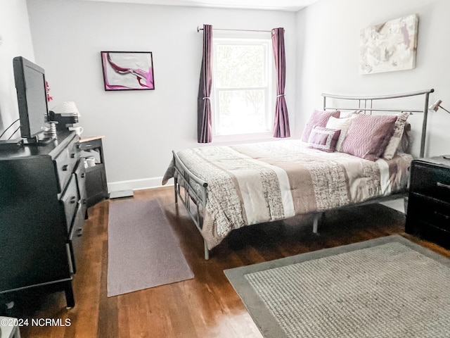 bedroom featuring baseboards and wood finished floors