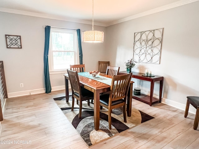 dining area featuring crown molding, light wood-style flooring, and baseboards