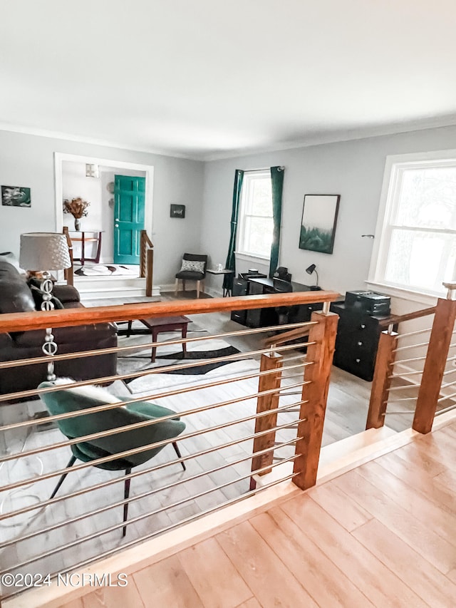 living room with plenty of natural light, crown molding, and hardwood / wood-style floors