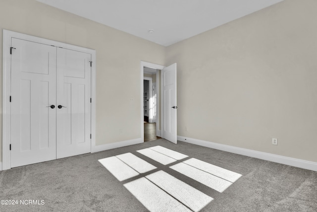 unfurnished bedroom with a closet, baseboards, and carpet floors