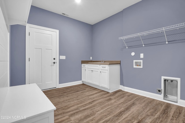 washroom with wood finished floors, visible vents, hookup for an electric dryer, cabinet space, and washer hookup