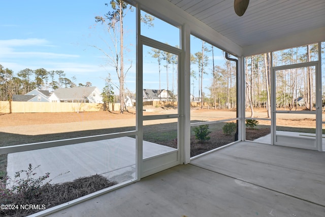 unfurnished sunroom featuring a ceiling fan