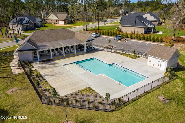 view of pool with fence, a yard, a residential view, a fenced in pool, and a patio area