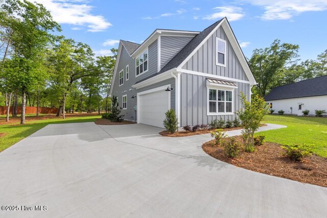 233 Hampton Ct, Hampstead, NC 28443 - view of home's exterior featuring concrete driveway, board and batten siding, a shingled roof, and a lawn