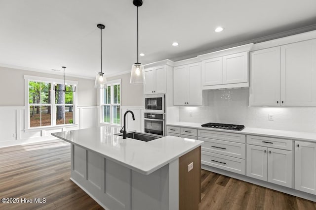 233 Hampton Ct, Hampstead, NC 28443 - kitchen featuring crown molding, tasteful backsplash, an island with sink, stainless steel appliances, and white cabinetry