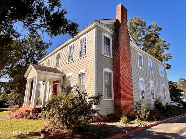 view of side of property featuring crawl space and a chimney