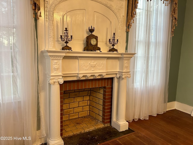 interior details featuring a brick fireplace, baseboards, and wood finished floors