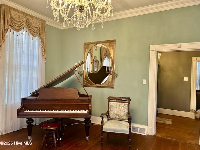 sitting room with wood finished floors, visible vents, and crown molding