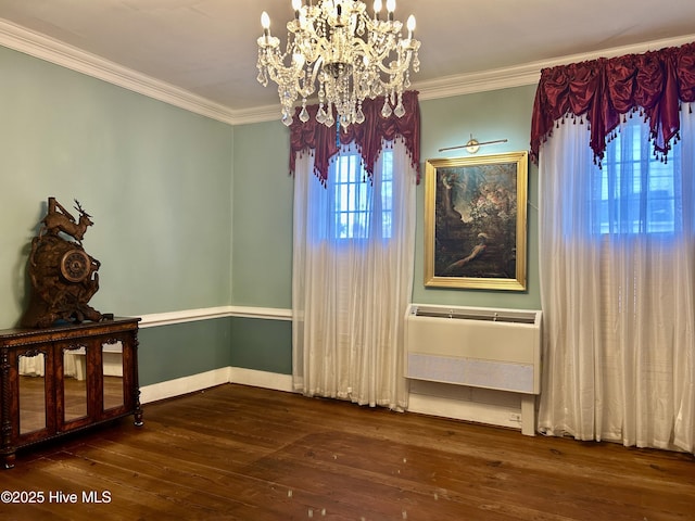 unfurnished dining area with ornamental molding, a chandelier, a wall mounted air conditioner, and dark wood-style floors