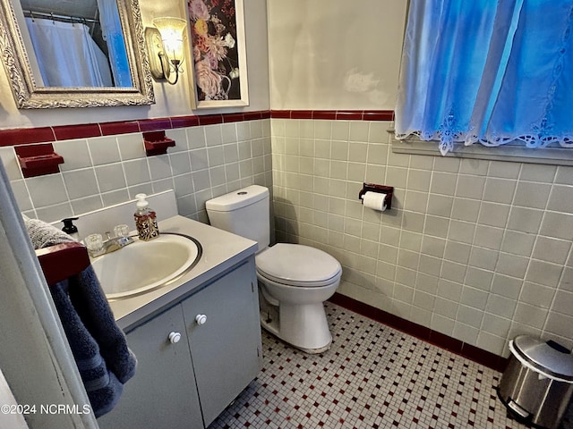 bathroom featuring tile walls, vanity, toilet, and tile patterned floors