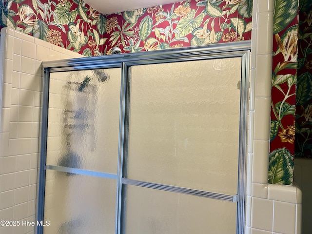 interior space featuring a shower with door and wallpapered walls