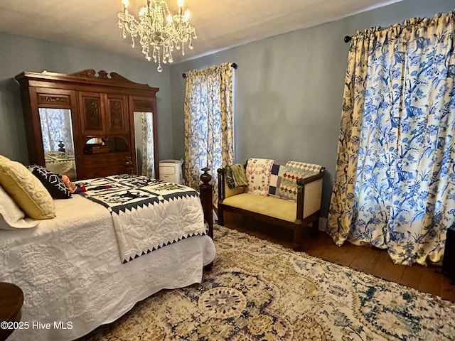 bedroom with an inviting chandelier and dark wood finished floors