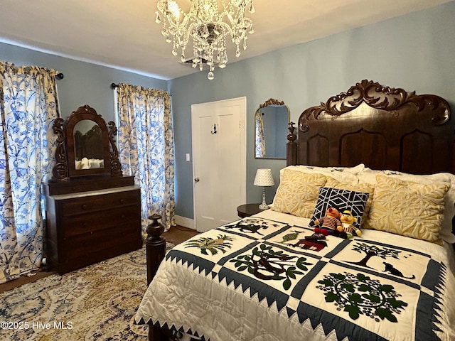 bedroom with a chandelier and baseboards