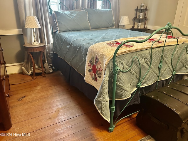 bedroom with baseboards and wood finished floors