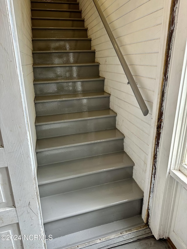 stairs featuring wooden walls