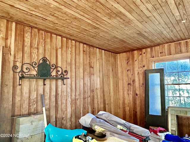 unfurnished bedroom featuring wooden ceiling and wood walls