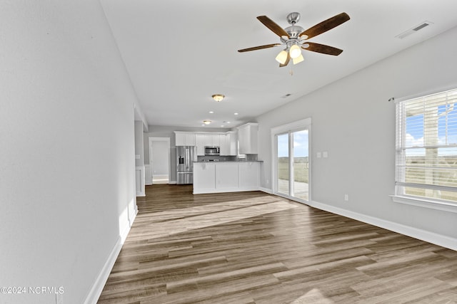 unfurnished living room featuring ceiling fan and light wood-type flooring