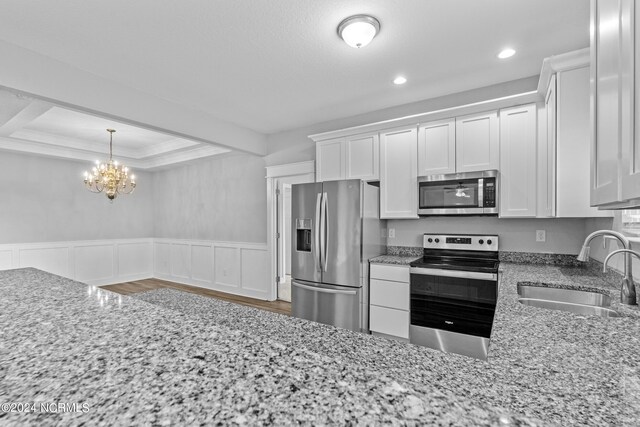 kitchen featuring plenty of natural light, white cabinetry, sink, and stainless steel appliances