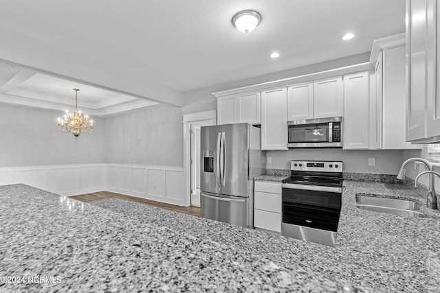 kitchen with white cabinetry, sink, stainless steel appliances, and light stone countertops