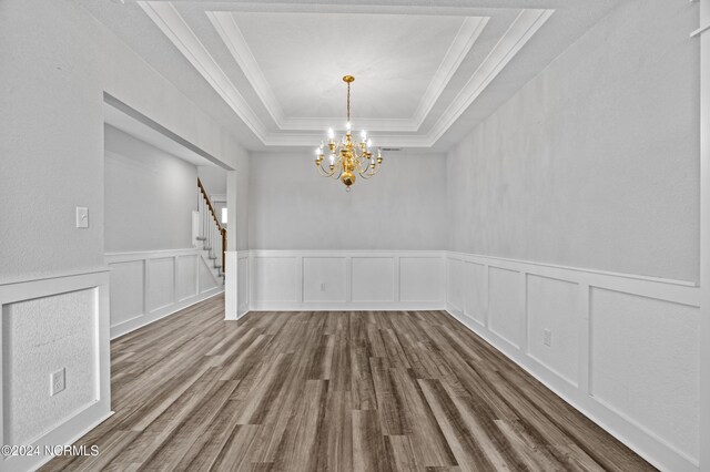 interior space with dark wood-type flooring, ornamental molding, and an inviting chandelier