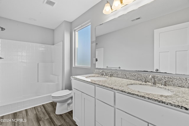 bathroom featuring vanity, hardwood / wood-style floors, toilet, and walk in shower