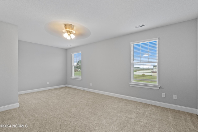 carpeted empty room with a textured ceiling and ceiling fan