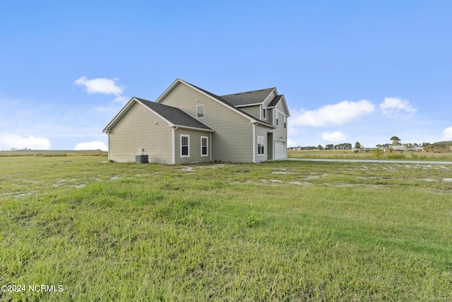 back of property featuring a rural view and a garage