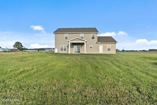 back of house featuring a rural view and a yard