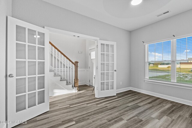 spare room featuring hardwood / wood-style flooring and french doors