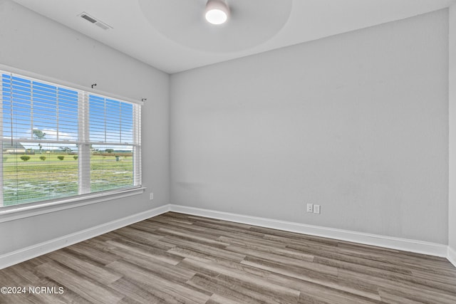 empty room with hardwood / wood-style floors and ceiling fan