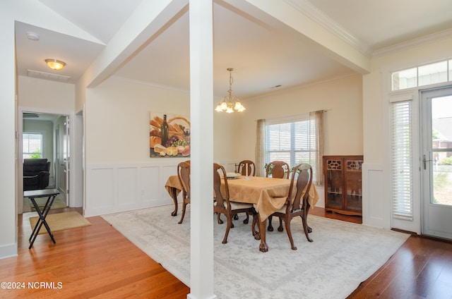 dining space featuring ornamental molding, a chandelier, and hardwood / wood-style flooring