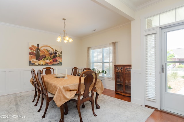 dining space with light hardwood / wood-style flooring, a chandelier, and ornamental molding