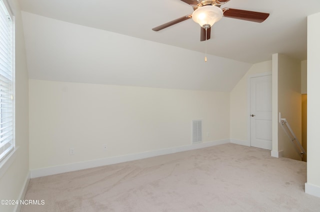 additional living space featuring lofted ceiling, carpet flooring, visible vents, ceiling fan, and baseboards