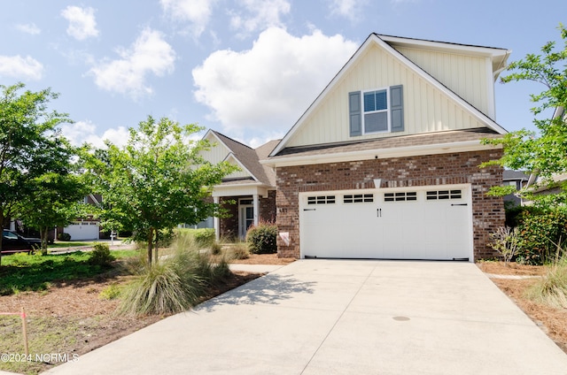 craftsman-style home featuring a garage, brick siding, board and batten siding, and concrete driveway