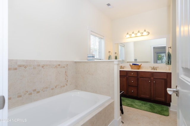 bathroom featuring vanity, tiled bath, and tile patterned flooring