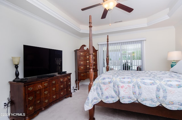 carpeted bedroom featuring crown molding, a tray ceiling, and ceiling fan