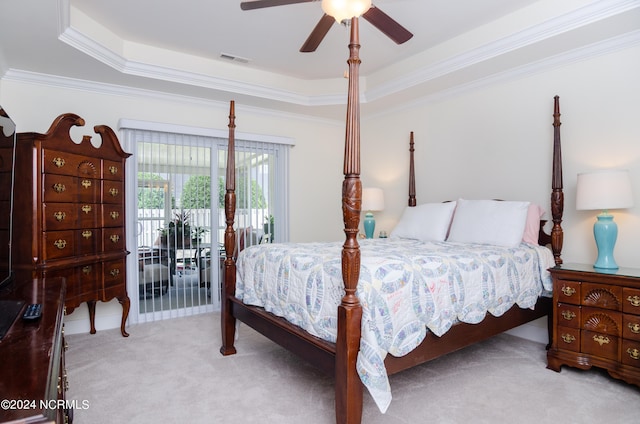 carpeted bedroom featuring access to outside, a tray ceiling, crown molding, and ceiling fan