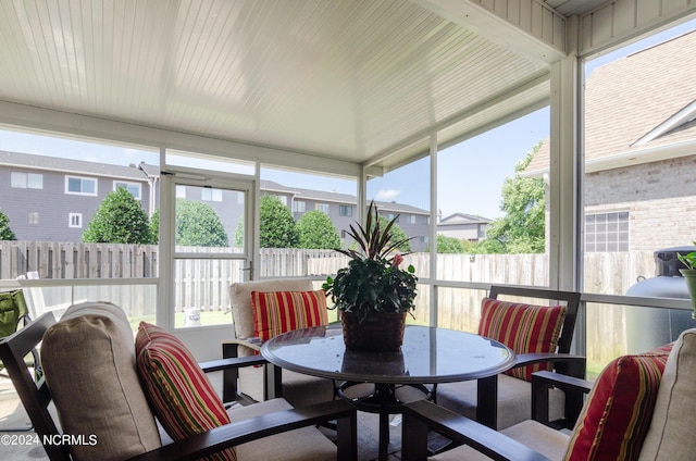 sunroom featuring outdoor dining area and plenty of natural light