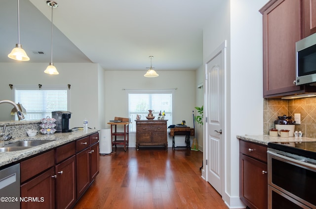 kitchen with pendant lighting, dark hardwood / wood-style flooring, sink, light stone counters, and appliances with stainless steel finishes