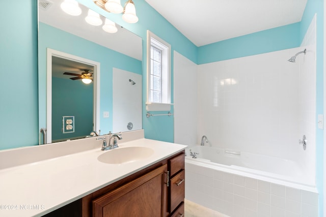 bathroom featuring vanity, tiled shower / bath, and ceiling fan