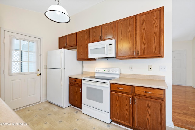 kitchen featuring hanging light fixtures, light wood-type flooring, and white appliances