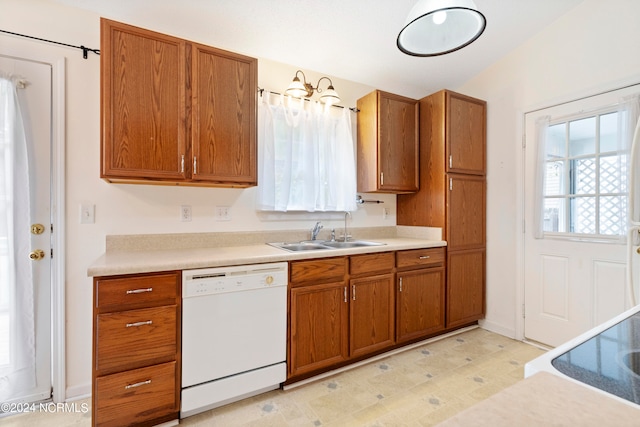 kitchen featuring lofted ceiling, stove, sink, and white dishwasher