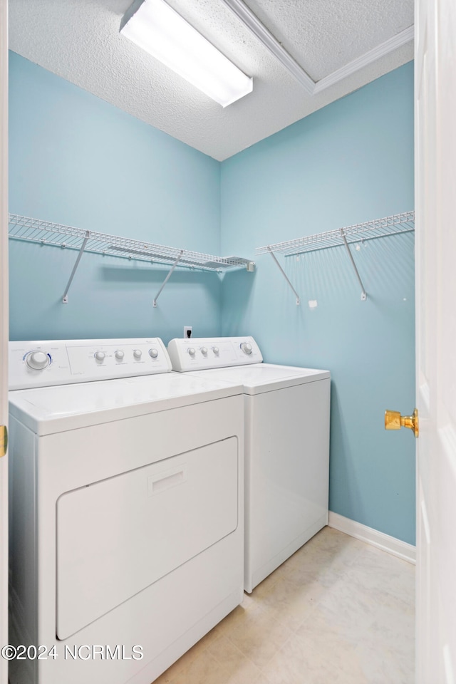 washroom featuring a textured ceiling and washer and clothes dryer