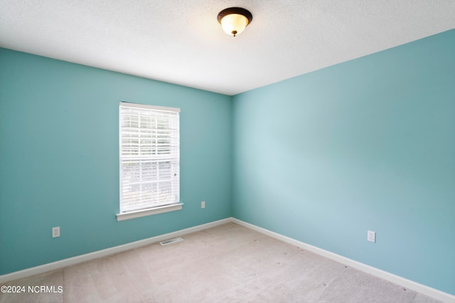 spare room with a textured ceiling and carpet floors