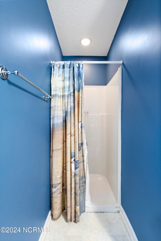 bathroom featuring a textured ceiling and a shower with shower curtain